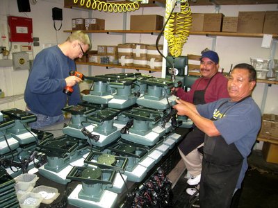 Three Men Focused On Numerous Massager Devices